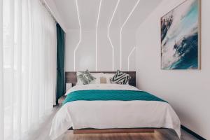 a bedroom with a large bed with white walls at Dali Mermaid Seascape Resort Hotel in Dali +137 photos