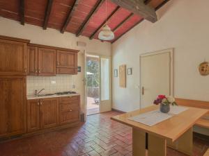 una grande cucina con armadi in legno e tavolo di Apartment Fattoria Petraglia - Terrazza by Interhome a Monteriggioni Altre 44 foto