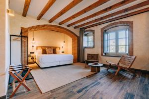 een slaapkamer met een bed en een stoel in een kamer bij Gran Claustre Boutique Hotel in Altafulla