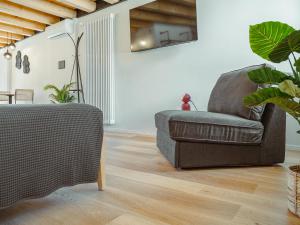 a living room with a couch and a chair at BRE Apartments - Lumen in Vicenza