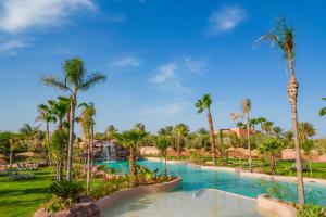 a pool at the resort with palm trees at Oasis lodges in Marrakesh