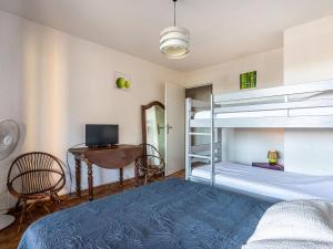 a bedroom with a bed and a desk and bunk beds at Apartment Les Regates-1 by Interhome in Hyères