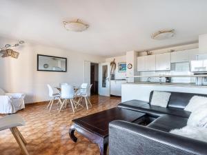 a living room with a couch and a table and a kitchen at Apartment Les Regates-1 by Interhome in Hyères