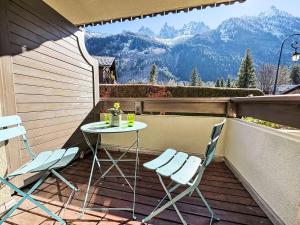 ein Tisch und Stühle auf einem Balkon mit Bergen in der Unterkunft Apartment Ginabelle 1-2 by Interhome in Chamonix-Mont-Blanc