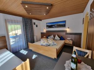 a bedroom with a bed and a table with a bottle of wine at Holiday Home Vesul by Interhome in Kappl