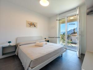 a bedroom with a large bed and a balcony at Apartment Le Lac by Interhome in Gravedona