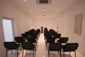 a row of chairs in a room with a row of tables and chairs at Achilleos City Hotel in Larnaca