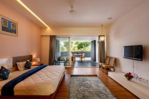 a bedroom with a large bed and a living room at St Jacinto Island Villa10 2Pools Bay View in Dabolim