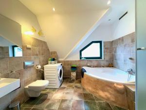 a bathroom with a tub and a toilet and a sink at Ferienwohnung am Berliner Stadtrand in Berlin +19 photos