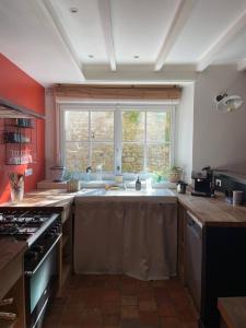 a kitchen with a sink and a large window at Maison de Bourg en Pierre au cœur de Plouharnel in Plouharnel +12 photos