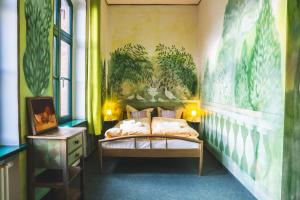 een slaapkamer met een bed met planten aan de muur bij Pension Spreewelten in Lübbenau