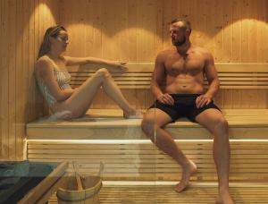 ポルツェスにあるSt Moritz Hotel Apartmentsのサウナに座っている男性と女性
