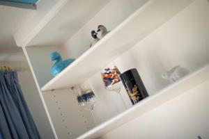 a white staircase with shelves and a blue bird on it at Uaster Reeg II Maisonette in Archsum