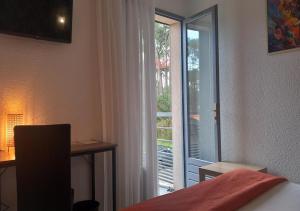 a room with a bed and a sliding glass door at Les Jardins de L'Ocean - Climatisé in Biscarrosse-Plage