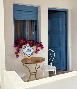 une table et des chaises devant une porte bleue dans l'établissement Álas Holiday Home, à Archangelos