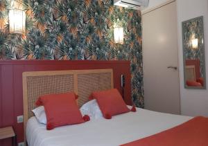 a bedroom with a bed with two red pillows at Les Jardins de L'Ocean - Climatisé in Biscarrosse-Plage