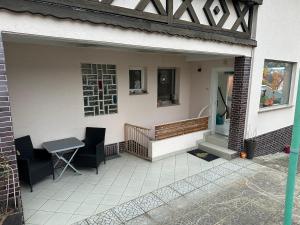 a patio with a table and chairs on a house at Ferienwohnung Am Kirschbaum Mömlingen in Momlingen