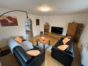 a living room with two couches and a table at Ferienwohnung Am Kirschbaum Mömlingen in Momlingen