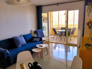 a living room with a blue couch and a table at 1ª linea del mar 2 habitaciones 2 baños, parking subterraneo incluido, mascotas in El Campello