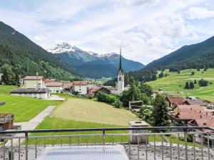 a view of a village with a church and mountains at Apartment Cresta - SAV125 by Interhome in Savognin