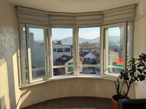 een raam met uitzicht op een stad en de bergen bij SleepInNP in Novi Pazar +2 foto's