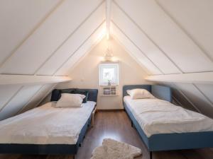 two beds in a attic room with white ceilings at Holiday Home Beluga with parking and shared pool by Interhome in De Haan