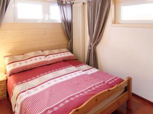 a bed in a room with two windows at Apartment Les Cimes by Interhome in Les Crosets +23 photos