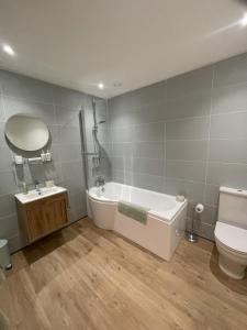 Un baño con bañera, inodoro y lavabo. en Estuary's Rest Studio Apartment at Galwad Y Mor, en Cardigan