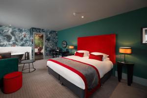 a bedroom with a large bed with a red headboard at Malmaison Aberdeen in Aberdeen +85 photos