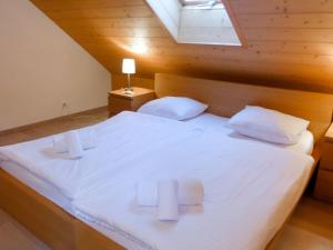 a bedroom with a large white bed with a skylight at Apartment Andromède 4 pièces 11 by Interhome in Moleson