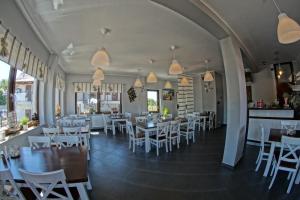 a dining room with white tables and white chairs at Pokoje i Restauracja Jantarowa in Jantar