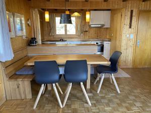 a kitchen with a wooden table and two blue chairs at Chalet Chalet Soldanella - BEL205 by Interhome in Bellwald