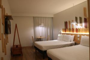 Postel nebo postele na pokoji v ubytování Hotel Nacional Inn Curitiba Santa Felicidade