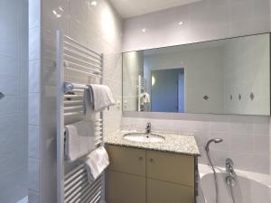 a bathroom with a sink and a tub and a mirror at Apartment Reine Marine- T2 SUD by Interhome in Saint Malo