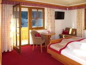 卡普尔Apartment Apart Garni Royal-1 by Interhome的一间卧室，里面有一张床、一张桌子和一把椅子