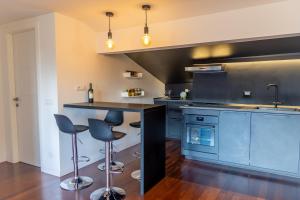 a large kitchen with blue cabinets and bar stools at gandino apartment in Rome