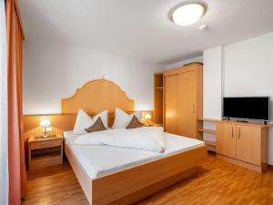 a bedroom with a bed and a flat screen tv at Apartment Rosa-2 by Interhome in Mayrhofen