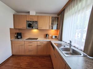 a kitchen with wooden cabinets and a sink and a window at Apartment Rosa-2 by Interhome in Mayrhofen