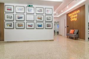una hall con una parete bianca e delle immagini di Designer - 60 Seconds to the Beach I Free Parking! a San Giuliano