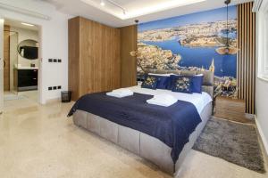 una camera da letto con un grande letto e un grande dipinto sul muro di Designer - 60 Seconds to the Beach I Free Parking! a San Giuliano