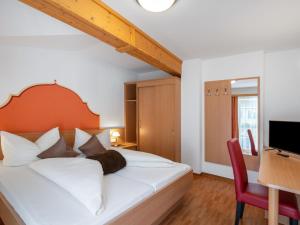 a bedroom with a bed and a desk and a television at Apartment Rosa-1 by Interhome in Mayrhofen +19 photos