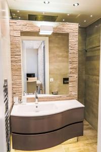 a bathroom with a sink and a large mirror at Apartment Flaminia 39 by Interhome in Leukerbad +5 photos