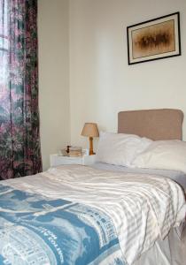 a bedroom with a bed with a blanket and a window at The Bukoto Loft in Kampala