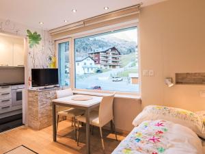 a bedroom with a table and a bed and a window at Studio Cristal 36 by Interhome in Leukerbad