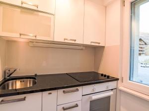 a kitchen with white cabinets and a sink and a window at Studio Cristal 36 by Interhome in Leukerbad