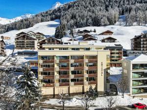 a building in the snow with a mountain at Apartment Cristal-4 by Interhome in Leukerbad