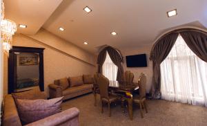 Una sala de estar con un sofá y una mesa con sillas. en Baku Hotel Ganja, en Ganja