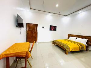 Résidences hôtels sibontour في ياموسوكرو: غرفة نوم بها سريرين وتلفزيون بداخلها