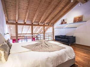 a bedroom with a large bed and a couch at Apartment Chesa Alossa by Interhome in La Punt-Chamues-ch