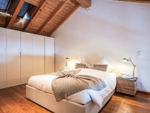 a bedroom with a large bed and a wooden ceiling at Apartment Chesa Alossa by Interhome in La Punt-Chamues-ch